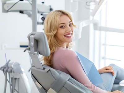 Smiling dental patient looking over her shoulder