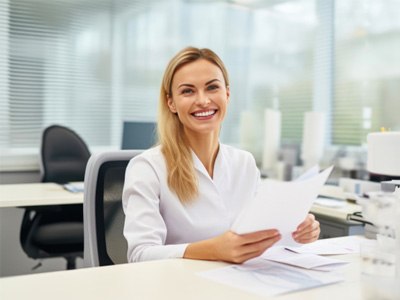 Smiling member of dental office front desk team