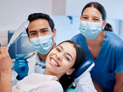 Happy patient posing with dental team