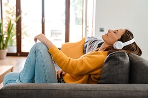 Woman resting at home while listening to music