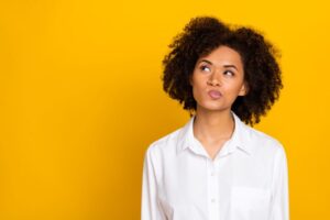 Woman in white blouse wearing curious, thoughtful expression